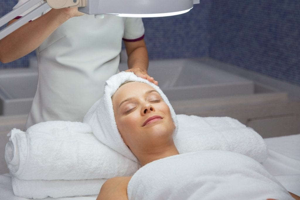 Woman wearing towel receiving medical grade facial treatment