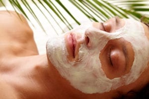 Woman wearing facial mask in tropical setting