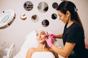 Woman receiving facial treatment in spa-like setting